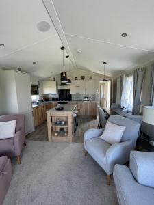塞顿港Seton sands holiday park - Premium caravan - 2 bedroom sleeps 4的一间带两张沙发的客厅和一间厨房
