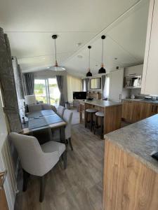塞顿港Seton sands holiday park - Premium caravan - 2 bedroom sleeps 4的厨房配有桌椅和柜台。