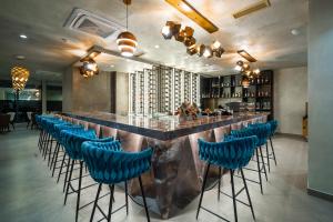 格勒姆Pinea Hotel Resort & Spa的餐厅内带蓝色酒吧凳的酒吧