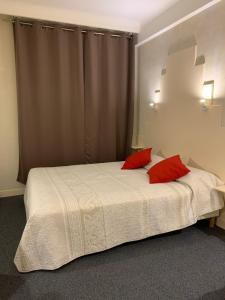 阿尔比密码酒店的一间卧室配有一张带两个红色枕头的床