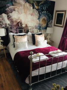 伯翰姆昂斯One ninety Boutique Accommodation的一间卧室配有一张带花卉墙壁的床