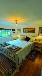JordanstownCharming Victorian Coach House的卧室配有一张带两张桌子的大型白色床
