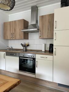 维林根Appartement 5 Willingen的厨房配有白色橱柜和烤箱。