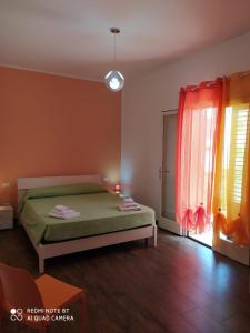 圣维托罗卡波伊尔佩佩罗尼诺公寓的一间卧室设有一张绿色的床和一个窗户。
