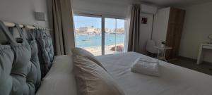 锡拉库扎Eos Sea View Apartments的一间卧室设有一张床,享有海景
