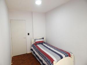罗萨里奥Apartamento的一间小卧室,在白色的房间里配有一张床
