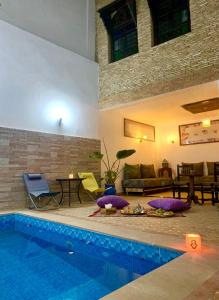 梅克内斯里亚德扎拉阿尔伊斯梅利亚住宿加早餐旅馆的客厅设有游泳池和沙发