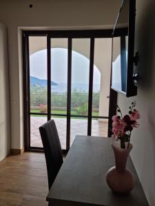 阿格罗波利Qvattro stagioni panoramic suites的一间带桌子和花瓶的用餐室