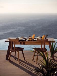圣尼古拉奥斯Etheria Luxury Villas & Suites的天井顶部的木桌,带食物
