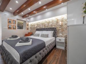 布德瓦Luxury Boutique Studio的一间卧室设有一张大床和砖墙