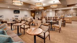 罗林斯贝斯特韦斯特木棉树宾馆的一间带桌椅的餐厅和一间酒吧