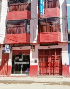 胡利亚卡Hostal Sumak'usi的红色和白色的建筑,设有铁窗