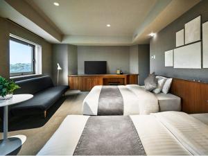 熊本The New Hotel Kumamoto -DLIGHT LIFE & HOTELS-的酒店客房,设有两张床和一张沙发