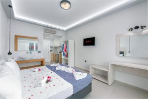 拉加纳斯Breeze Luxury Rooms的白色卧室设有床铺和水槽