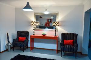 威特班克雅拉雅拉精品酒店 的一间设有两把椅子、一张桌子和一面镜子的房间
