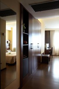 维戈维戈科亚酒店的一间设有一张床的房间和一间带镜子的房间
