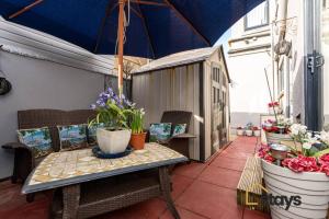 布莱克浦Seaview House的庭院配有桌椅和遮阳伞。