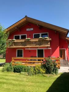 卡普伦Landhaus Elto的带阳台和木栅栏的红色房屋