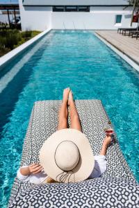 帕特诺斯特斯特兰特卢珀大洋精品酒店的坐在游泳池畔躺椅上的女人