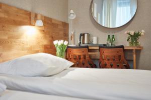 克拉科夫巴托丽酒店的一张带白色枕头和镜子的床