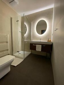 利普托斯基米库拉斯德拉科盆棕酒店的带淋浴、盥洗盆和镜子的浴室