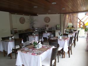 莫罗圣保罗Pousada Safira do Morro的餐厅配有桌椅和白色桌布