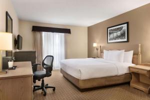 蒙克顿蒙克顿旅程套房酒店的配有一张床和一张书桌的酒店客房