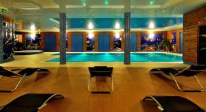 科宁HOTEL NIAGARA的一座游泳池,四周摆放着椅子