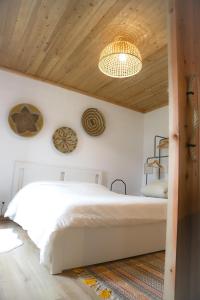 七城Sete Cidades Nature Villa的卧室设有白色的床和木制天花板。
