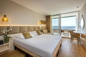 波尔托罗西斯特利安酒店的一间卧室设有一张大床,享有海景