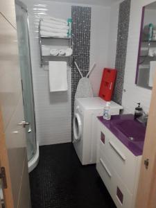 贝纳尔马德纳贝纳尔海滩茉莉公寓的浴室配有洗衣机和紫色水槽