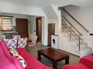 萨利杰尔梅海豚公寓式酒店的客厅配有粉红色的沙发和桌子