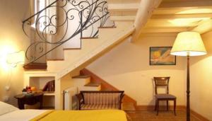 皮耶特拉伦加罗坎达德尔博尔戈酒店的一间卧室设有楼梯、一张床和一张桌子
