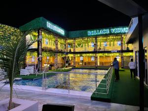 伊凯贾Rollace Hotel的一座建筑,在晚上前方有一个游泳池