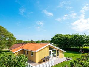 海默特6 person holiday home in Hemmet的一座黄色的小房子,有橙色的屋顶