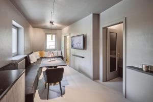 布列瑟农Stufels 7 Design Apartment with Brixen Card的厨房以及带桌椅的起居室。