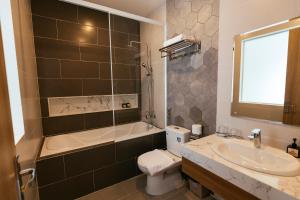 大叻Minh Chi Hotel的浴室配有盥洗盆、卫生间和浴缸。