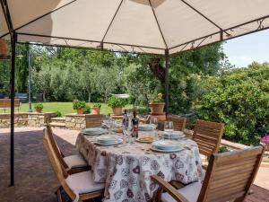 拉达-因基安蒂Holiday Home Villa del Poggio by Interhome的露台的遮阳伞下的桌椅