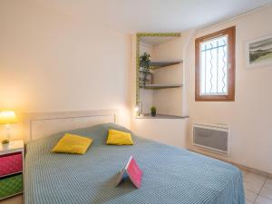比亚里茨Apartment Coulaoun by Interhome的一间卧室配有一张带两个黄色枕头的床