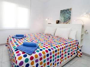 莱斯卡拉Apartment Garbi Park by Interhome的一间卧室配有一张色彩缤纷的床和枕头。