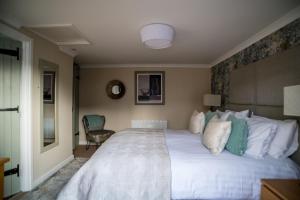 MiltonThe Brewers Inn的卧室配有一张白色大床和一把椅子