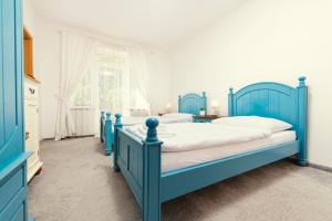 克赛拉迪Hotel Ostende的一间蓝色卧室,配有两张床和窗户