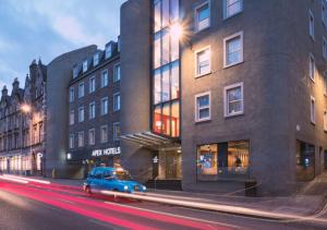 爱丁堡派克斯爱丁堡城市酒店的停在大楼前的蓝色汽车