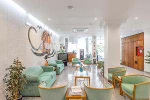 卡帕里卡海岸科利柏酒店的一间设有绿色椅子和桌子的等候室