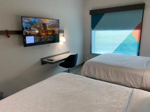 波特兰AVID Hotels Corpus Christi - Portland, an IHG Hotel的酒店客房设有两张床和一台平面电视。