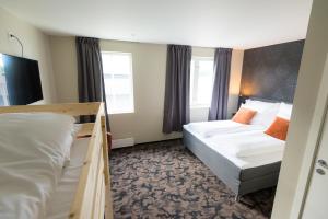桑内舍恩Sandnessjøen Overnatting的酒店客房带两张床和两个窗户