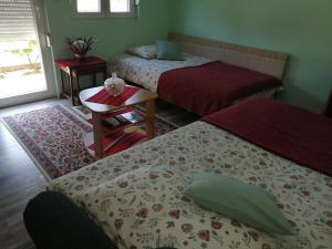 Surčin飞机T&T公寓的一间卧室设有两张床、一张桌子和一个窗口