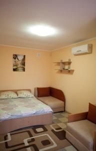 扎托卡Лиманский Берег的一间卧室配有一张床、一张沙发和一把椅子