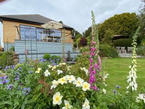 科克茅斯Westwood - The B&B with a view的一座花园,在房子前种有鲜花