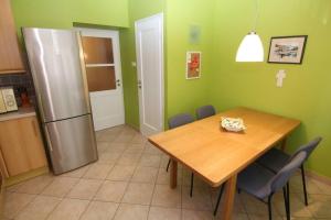 里耶卡Fast Friend - cozy apartment in the center with private garage的厨房配有木桌和冰箱。